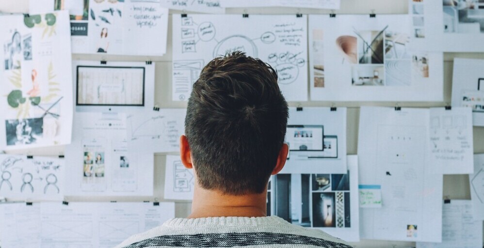 man looking at pinup board